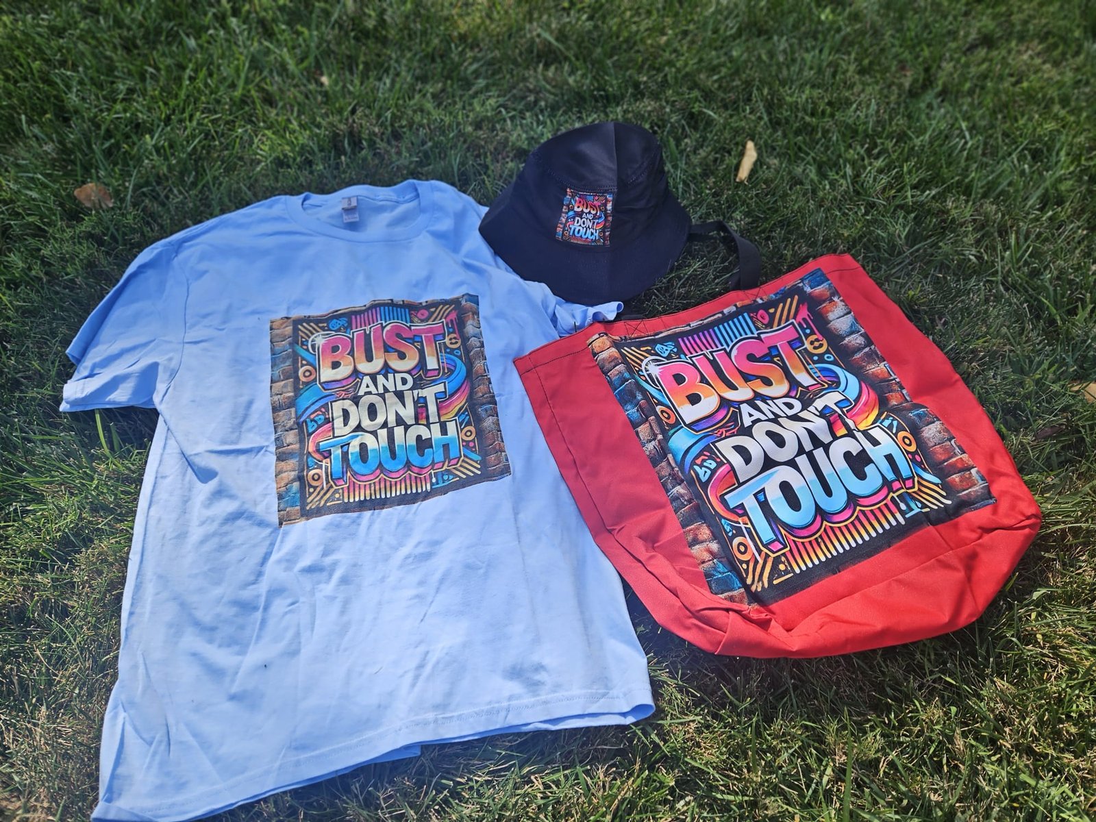 Hat, shirt, and bag merchandise photo on grass